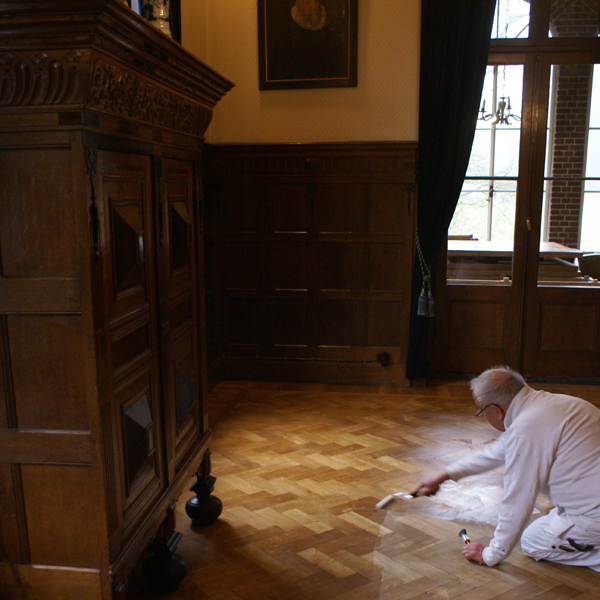 De mooie houten vloer in de sfeervolle 'Huiskamer' van Kasteel Hoekelum in Bennekom wordt door Van Reemst voorzien van een goede nieuwe laklaag en glanst!